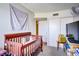 Bright bedroom with a crib, closet, and TV at 5706 W Lake Mead Blvd, Las Vegas, NV 89108