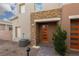 Contemporary home exterior with stone accents, an orange front door, and tidy landscaping at 600 N Carriage Hill Dr # 1081, Las Vegas, NV 89138