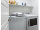 Clean laundry area showcasing a modern washer and dryer with convenient overhead storage at 600 N Carriage Hill Dr # 1081, Las Vegas, NV 89138