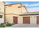 Home exterior showcasing garages, neutral paint, and a blue sky at 6110 Scarlet Leaf St, Las Vegas, NV 89148