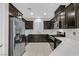 Modern kitchen featuring dark cabinets, stainless steel appliances, and marble countertops at 6110 Scarlet Leaf St, Las Vegas, NV 89148