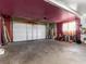 Spacious garage with a white door and a red-painted accent wall at 6117 Borden Cir, Las Vegas, NV 89107