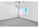 Bright bedroom features plush carpet, a ceiling fan, and natural light from the two windows at 6329 Sandy Ridge St # 1, North Las Vegas, NV 89081