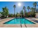 Community pool featuring clear blue water, palm trees, and lounge chairs at 6329 Sandy Ridge St # 1, North Las Vegas, NV 89081