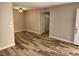 Neutral living room with wood-look flooring, new paint, and modern light fixture at 7200 Pirates Cove Rd # 1014, Las Vegas, NV 89145