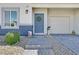 Charming home featuring a welcoming blue front door with a wreath, complemented by a well-maintained walkway at 7456 Cooks Meadow St, North Las Vegas, NV 89084