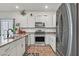 Modern kitchen featuring stainless steel appliances and granite countertops, wooden floors and white cabinetry at 7456 Cooks Meadow St, North Las Vegas, NV 89084