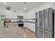 Well-lit kitchen featuring stainless steel appliances, granite countertops, and ample white cabinet space at 7456 Cooks Meadow St, North Las Vegas, NV 89084