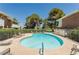 Beautiful community pool with lounge chairs, mature landscaping, and sparkling clear water on a bright sunny day at 778 Oakmont Ave # 312, Las Vegas, NV 89109