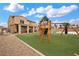 The backyard has a play structure on artificial turf with a covered patio attached to the house at 7825 Alameda Creek St, Las Vegas, NV 89113
