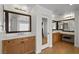 Bathroom with dual vanities, wood cabinets, and a makeup vanity area at 7825 Alameda Creek St, Las Vegas, NV 89113