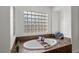 Bathroom featuring a soaking tub and glass block windows for natural light at 7825 Alameda Creek St, Las Vegas, NV 89113