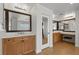 Bathroom featuring dual vanities, wood cabinets, large mirrors, and tile floors at 7825 Alameda Creek St, Las Vegas, NV 89113