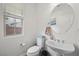 Bright powder room featuring a pedestal sink, toilet, and window with white blinds at 7825 Alameda Creek St, Las Vegas, NV 89113