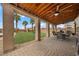 Covered patio with furniture overlooking a backyard play set, grass, and palm trees at 7825 Alameda Creek St, Las Vegas, NV 89113
