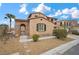 Inviting two-story home with an arched entry, tile roof, desert landscaping, and stone accents at 7825 Alameda Creek St, Las Vegas, NV 89113