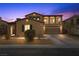 Inviting two-story home with a well-manicured front yard and attached two-car garage at dusk at 7825 Alameda Creek St, Las Vegas, NV 89113