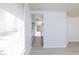 Hallway leads to a kitchen with white cabinets and stainless steel appliances at 92 Sea Holly Way, Henderson, NV 89074
