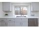 Kitchen sink and countertop beneath a window, white cabinetry and stainless dishwasher at 92 Sea Holly Way, Henderson, NV 89074