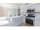 Modern kitchen with stainless steel appliances and a quartz countertop island at 92 Sea Holly Way, Henderson, NV 89074