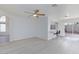 Open-concept living room features a ceiling fan, white walls, and light wood flooring at 92 Sea Holly Way, Henderson, NV 89074