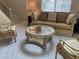 Living room with a beige couch, two chairs, and a glass coffee table at 9301 Harrow Rock St, Las Vegas, NV 89143