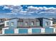 Aerial view of modern townhomes featuring blue garages and complementary facades against a partly cloudy blue sky at 9451 Calm Stream Ave # Lot 81, Las Vegas, NV 89178