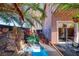 Picturesque backyard showcasing a charming patio area and a custom rock water feature at 101 Morning Dr, Henderson, NV 89012