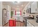 Cozy kitchen featuring stainless steel appliances, bright white cabinets, a movable red island, and wood flooring at 101 Morning Dr, Henderson, NV 89012