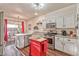 Well-lit kitchen with stainless steel appliances, white cabinetry, and a movable red island at 101 Morning Dr, Henderson, NV 89012
