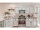 Charming kitchen with stainless steel appliances, white cabinets, and speckled countertops at 101 Morning Dr, Henderson, NV 89012