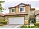 Two-story home with a white garage door, stone accents, and well-maintained landscaping at 10210 Juniper Creek Ln, Las Vegas, NV 89145