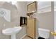 Cozy powder room featuring a pedestal sink, decorative mirror, cabinet, and toilet at 10457 Raining Sky St, Las Vegas, NV 89178