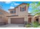 Two-story home with a two car garage and neutral colored facade and tasteful shutters at 10457 Raining Sky St, Las Vegas, NV 89178