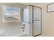 Bright bathroom featuring a soaking tub with shower and frosted glass door, offering both style and privacy at 1053 Hickory Park St, Las Vegas, NV 89138