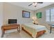 Cozy bedroom with a ceiling fan, large window, and a desk for work or study at 1053 Hickory Park St, Las Vegas, NV 89138