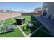Backyard with artificial turf, brick border, pavers, a built-in fire pit, and seating at 1122 Brilliant Meadow Ave, North Las Vegas, NV 89086