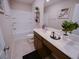 Well-lit bathroom featuring a tub with shower, and a vanity with white countertop and dark wood cabinets at 1122 Brilliant Meadow Ave, North Las Vegas, NV 89086
