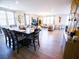 Open-concept living and dining area with hardwood floors, neutral decor, and large windows at 1122 Brilliant Meadow Ave, North Las Vegas, NV 89086
