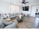 Bright living room with a large gray sectional, modern lighting, and an open doorway at 1122 Brilliant Meadow Ave, North Las Vegas, NV 89086