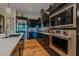 Close up on sleek kitchen featuring built-in oven, dark cabinets, and wood floors at 11477 Timber Mountain Ave, Las Vegas, NV 89135