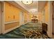 Well-lit hallway with patterned carpet leading to the elevators and other suites at 125 E Harmon Ave # 3220, Las Vegas, NV 89109