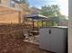 Outdoor patio featuring a dining set with umbrella, a Suncast storage shed and desert landscaping at 1463 Evening Song Ave, Henderson, NV 89012