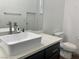 Bathroom with a toilet, dark wood cabinets, rectangle sink, and a large mirror at 1463 Evening Song Ave, Henderson, NV 89012