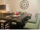 Modern dining area flowing into the kitchen, featuring stylish table and chairs with ample natural light at 1463 Evening Song Ave, Henderson, NV 89012