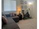 Inviting living room with a gray sectional, exercise bike and artwork on the walls at 1463 Evening Song Ave, Henderson, NV 89012