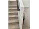 Carpeted staircase with a black handrail and white walls at 1463 Evening Song Ave, Henderson, NV 89012