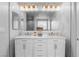 Bathroom featuring double sinks, white cabinets, granite countertop, and ample lighting at 1495 Le Luberon Ct, Las Vegas, NV 89123