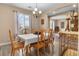 Inviting dining area with a chandelier, a large window, and a view into the connecting living room at 1495 Le Luberon Ct, Las Vegas, NV 89123