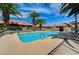 Community pool with lounge chairs, palm trees, and a clubhouse offers residents a relaxing retreat at 1839 Avacado Ct, Henderson, NV 89014